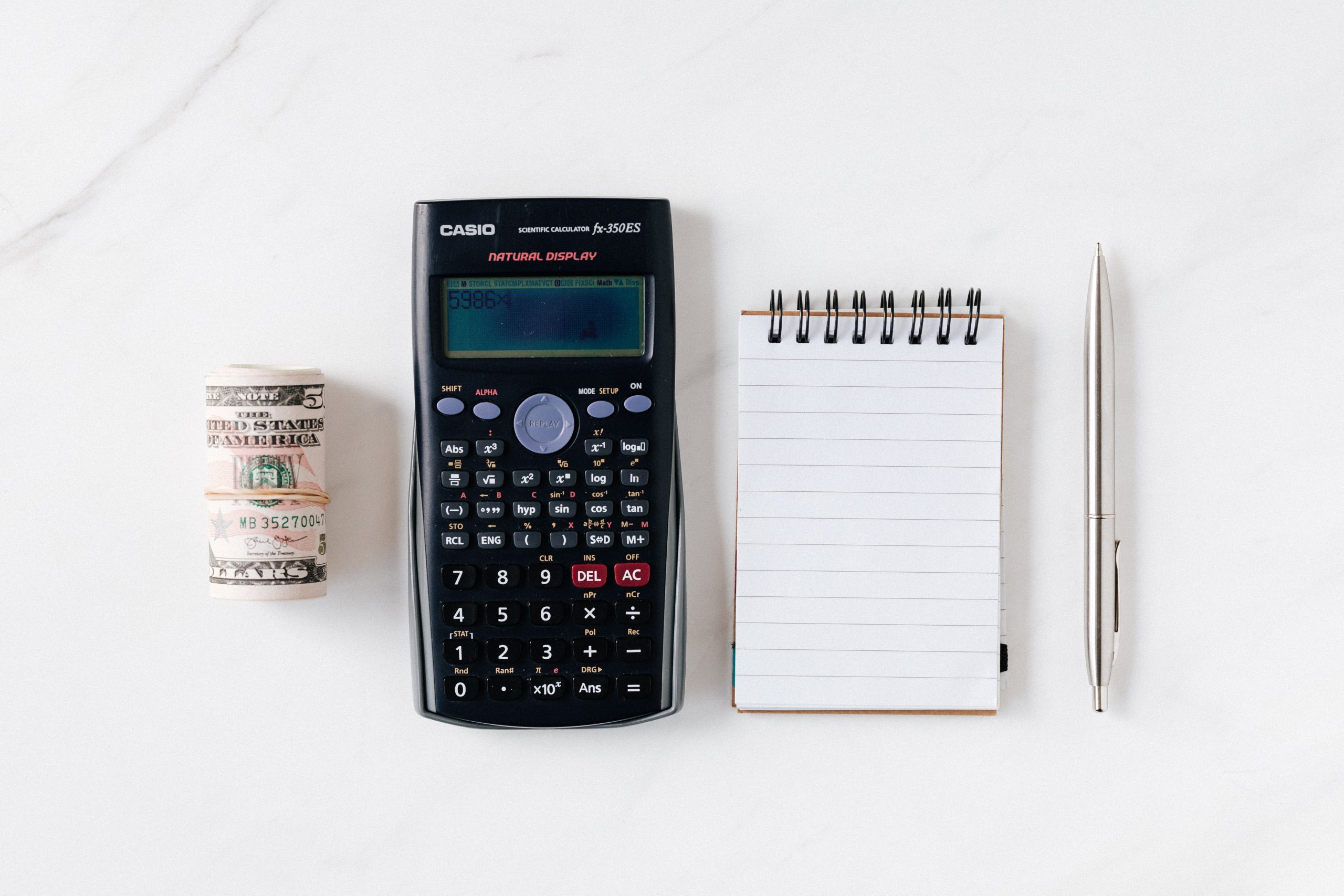 money, calculator, notebook, pen