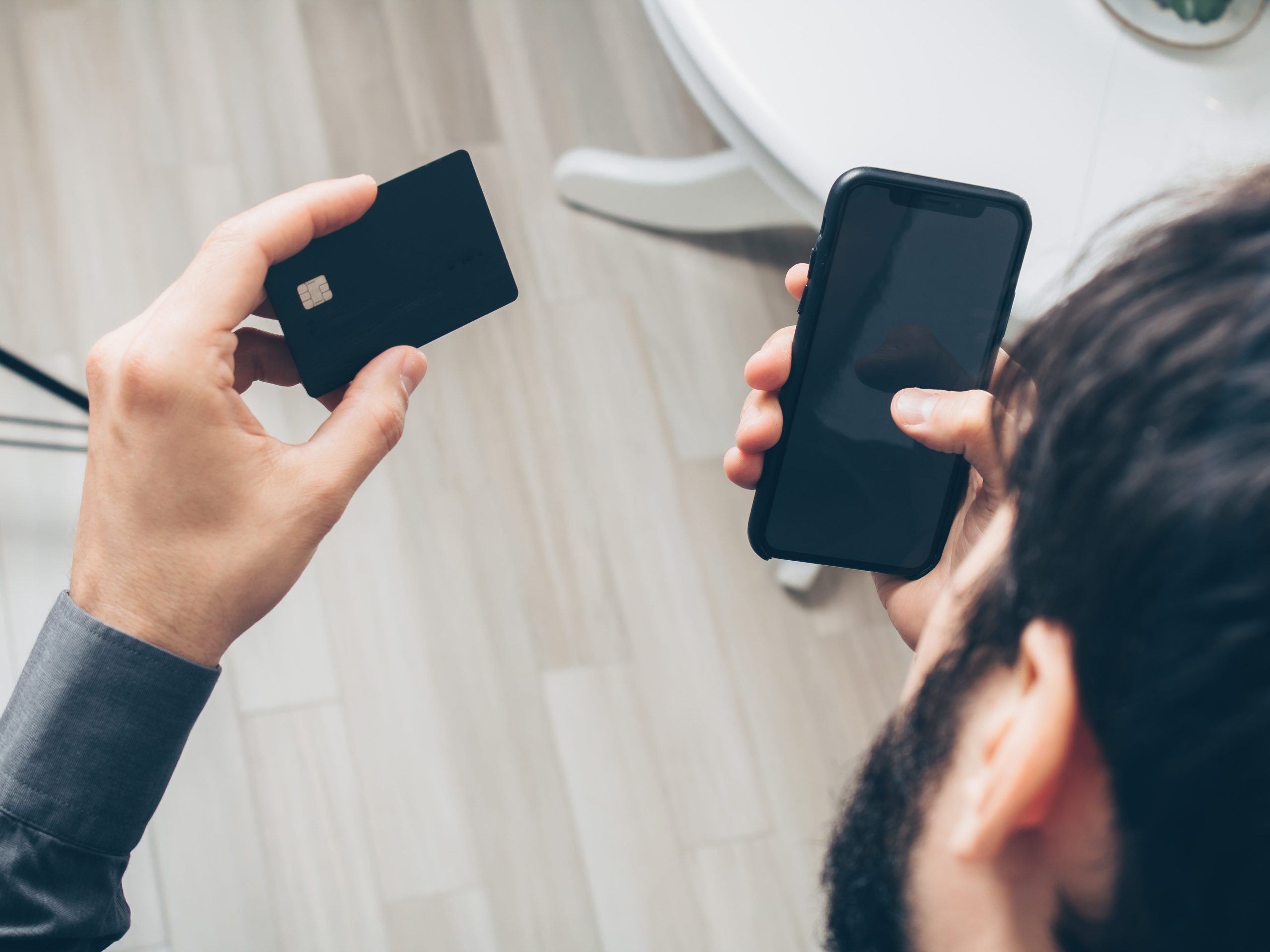 human holding an atm card and a phone